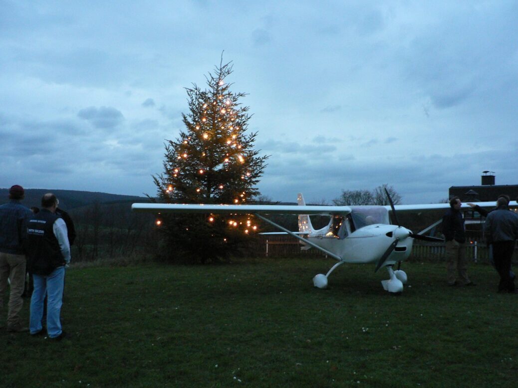 Ultraleichtflugzeug FK9 vor dem leuchtenden Weihnachtsbaum