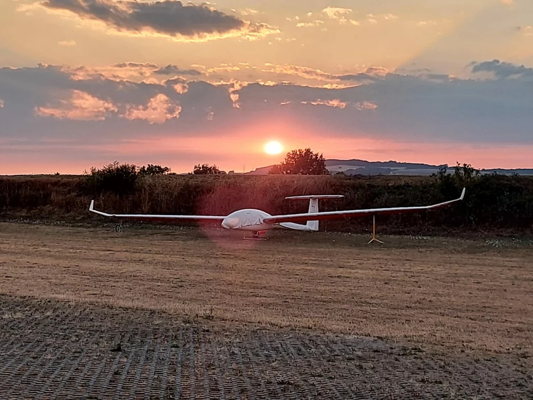 Eine DG 1000 steht nach einem Flugtag vor der untergehenden Sonne am Flugplatz Domberg